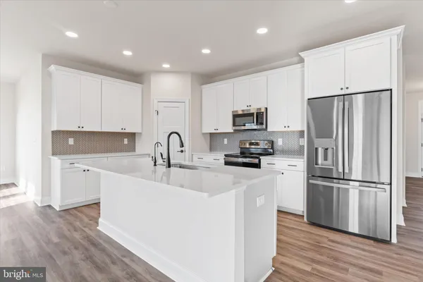 a kitchen with stainless steel appliances a refrigerator sink and microwave