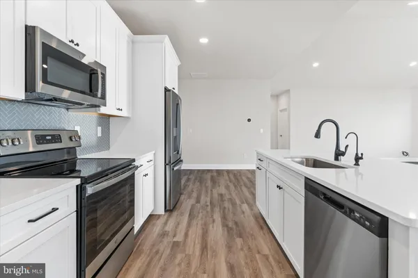 a kitchen with a sink stainless steel appliances and cabinets