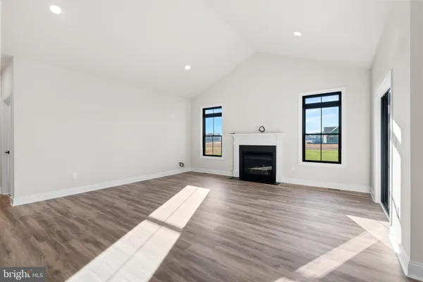 an empty room with wooden floor and fireplace