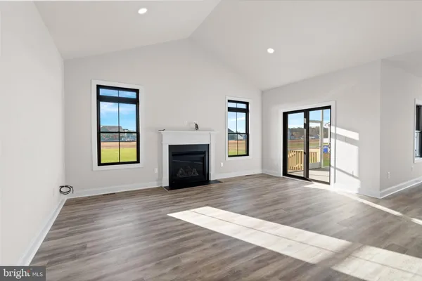 an empty room with windows and fireplace