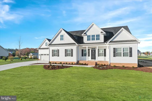 a white house with a big yard and more windows