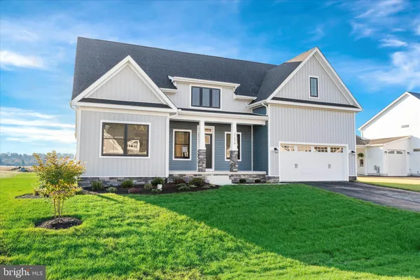 a front view of a house with a yard and trees
