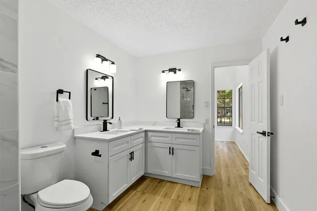 a bathroom with a sink a toilet and a mirror