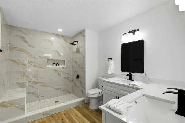 a bathroom with a granite countertop sink toilet and shower