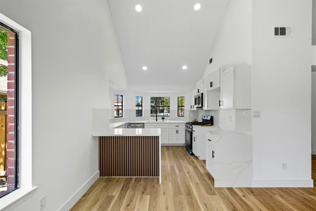 a kitchen with cabinets a sink and wooden floor