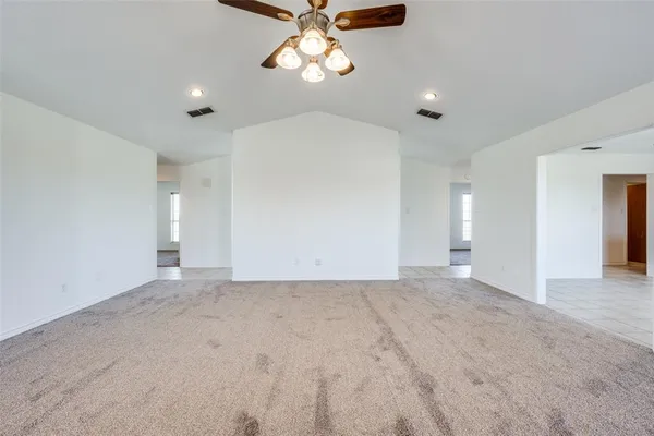 an empty room with windows and fireplace