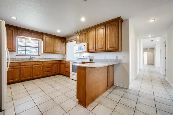 a kitchen with stainless steel appliances granite countertop a sink counter space cabinets and a large window