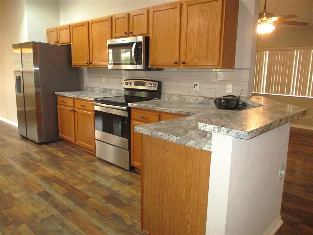 11536 Southwest 140th Loop Dunnellon, FL 34432 - Photo 6 of 75 a kitchen with stainless steel appliances granite countertop a refrigerator a stove a sink and a microwave