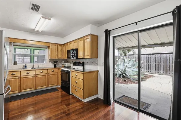 a kitchen with stainless steel appliances granite countertop a refrigerator a stove a sink and a granite countertops with wooden floor