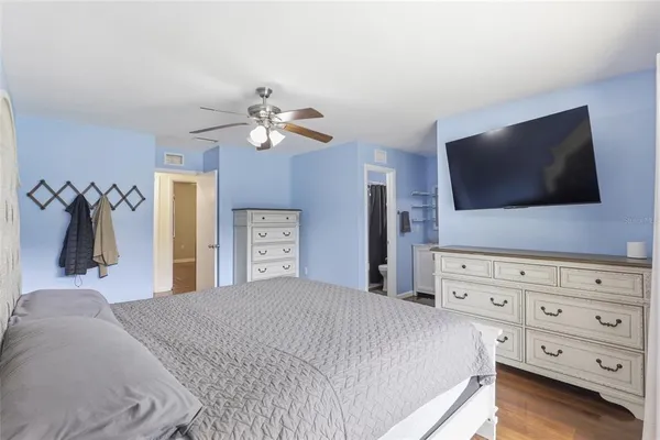 a bedroom with a bed and a flat tv screen on dresser