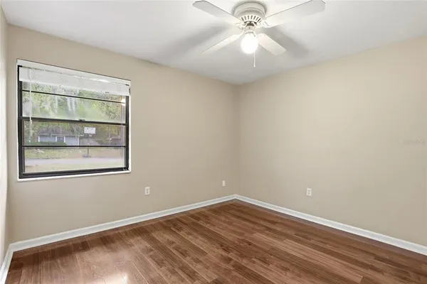 an empty room with a window and wooden floor