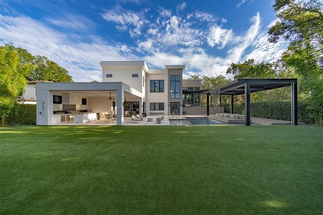 a view of a patio with table and chairs and a large tree