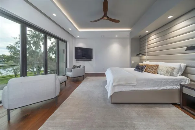 a spacious bedroom with a bed couch and large window