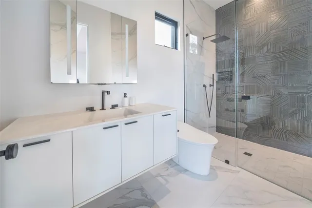 a bathroom with a double vanity sink toilet and shower