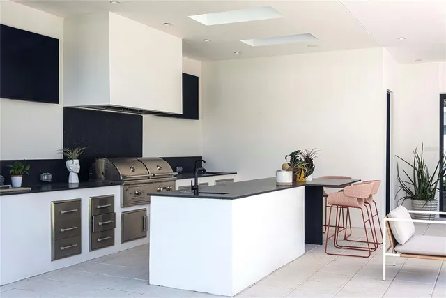 a kitchen with a sink a stove and chairs