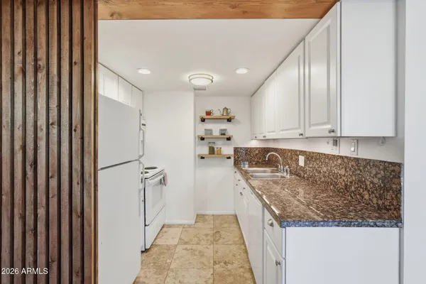 a kitchen with stainless steel appliances granite countertop a refrigerator and a stove