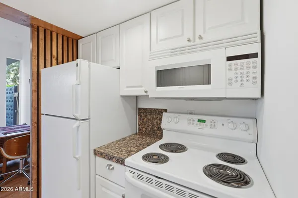 a white kitchen with a stove and a refrigerator