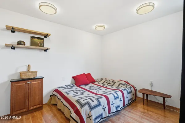 a bedroom with bed and wooden floor