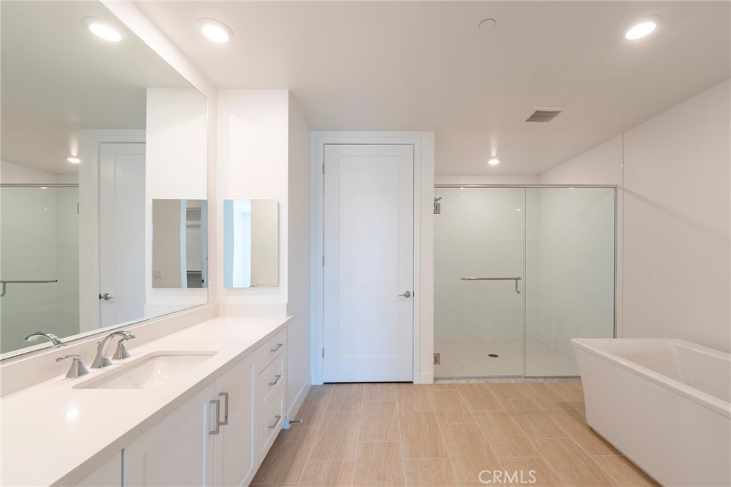 3211 Rivington Irvine, CA 92612 - Photo 18 of 49 a bathroom with a bathtub a double vanity sink and a large mirror