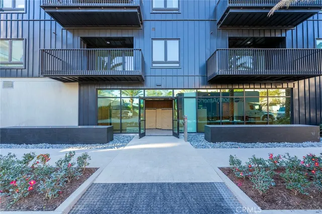 a view of a house with wooden fence and potted plants