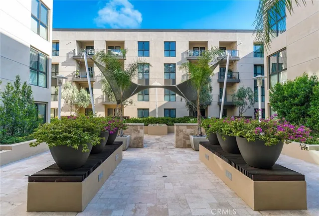 a view of a patio with table and chairs potted plants and large tree