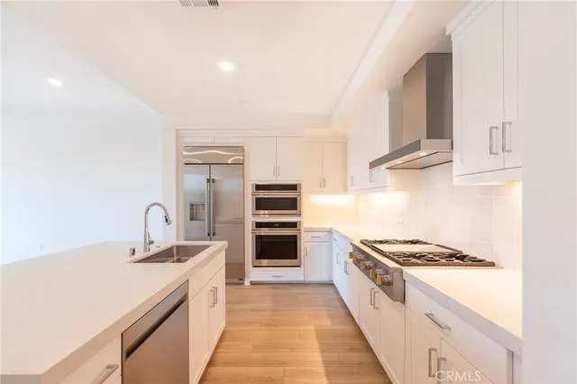 a kitchen with kitchen island stainless steel appliances a sink stove and refrigerator