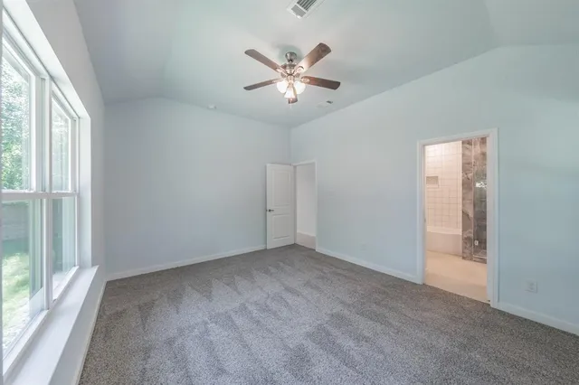 an empty room with ceiling fan and window