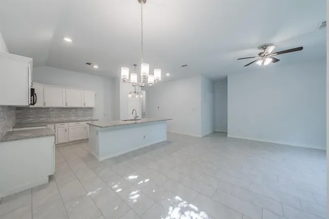 a view of an empty room and kitchen view