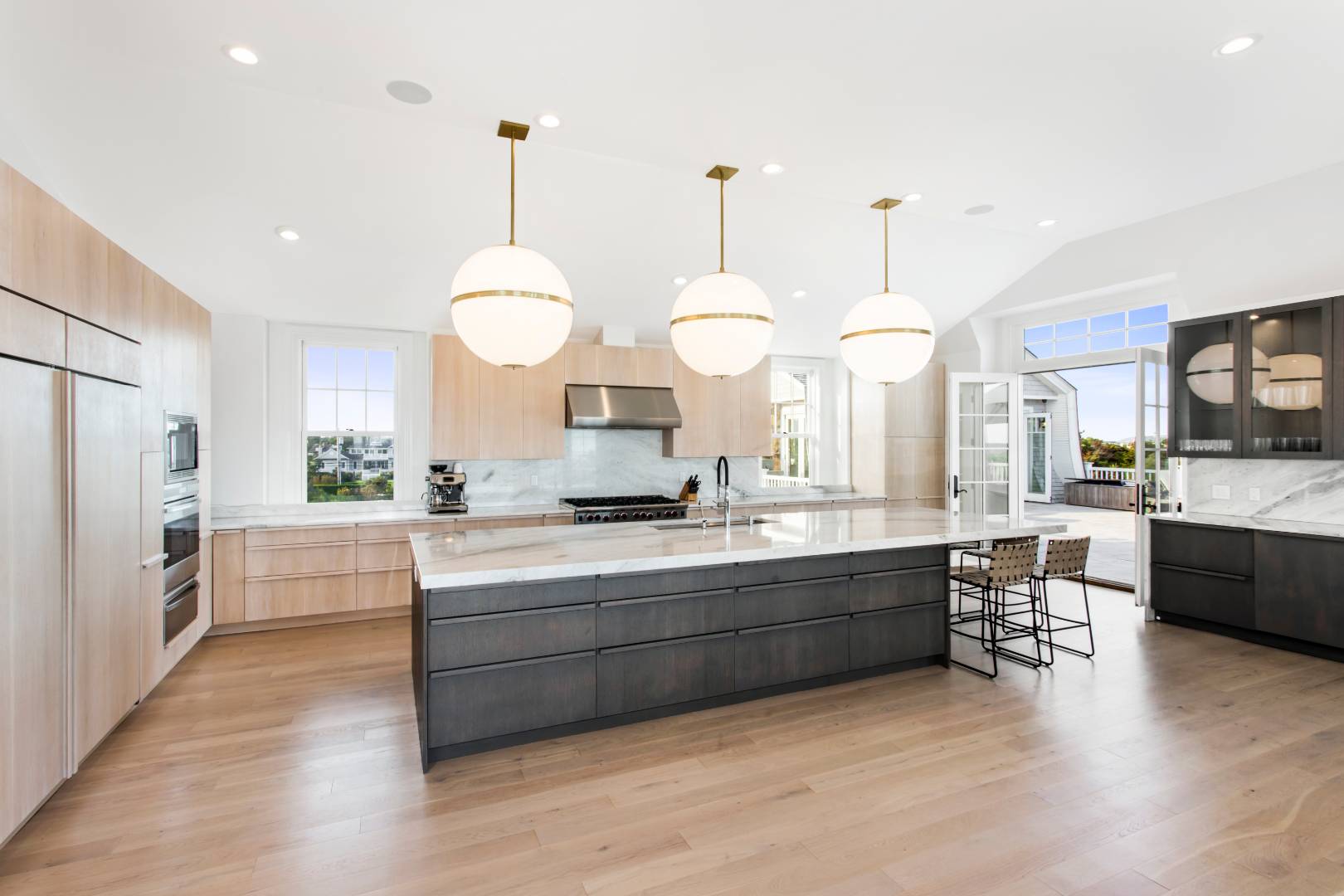 124 Dune Road Quogue, NY 11959 - Photo 11 of 34 a large white kitchen with a large island oven a stove a dining table and chairs