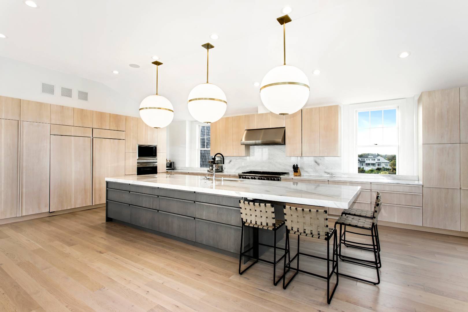 124 Dune Road Quogue, NY 11959 - Photo 13 of 34 a kitchen with stainless steel appliances granite countertop a sink a stove and chairs