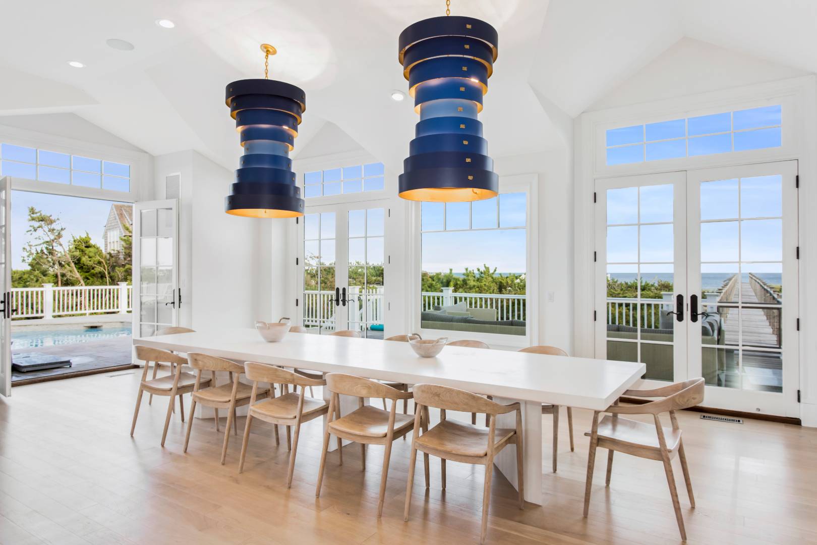124 Dune Road Quogue, NY 11959 - Photo 14 of 34 a dining room with furniture a chandelier and wooden floor