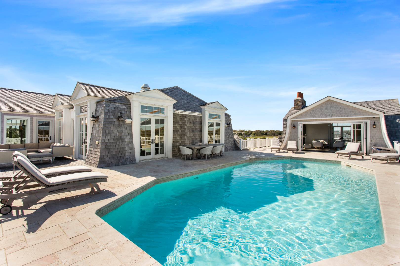 124 Dune Road Quogue, NY 11959 - Photo 19 of 34 a front view of a house with swimming pool having outdoor seating