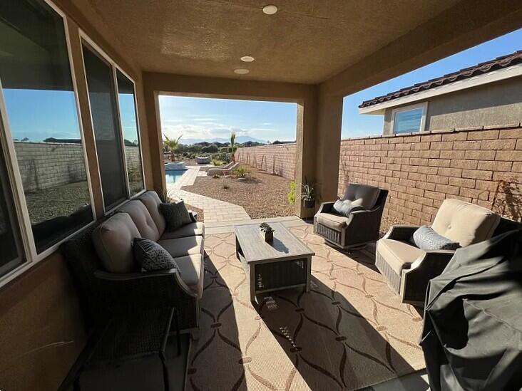 41867 Regona Road Indio, CA 92203 - Photo 28 of 65 a living room with furniture and a floor to ceiling window