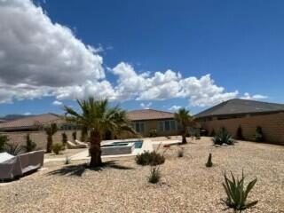 41867 Regona Road Indio, CA 92203 - Photo 45 of 65 a view of patio with a table and chairs under an umbrella next to a yard