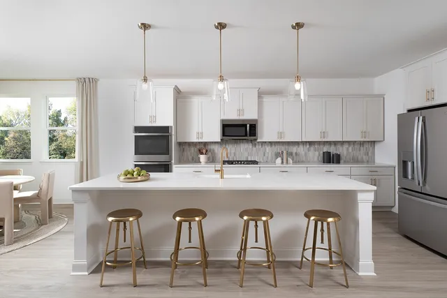 a kitchen with kitchen island a stove a table and chairs