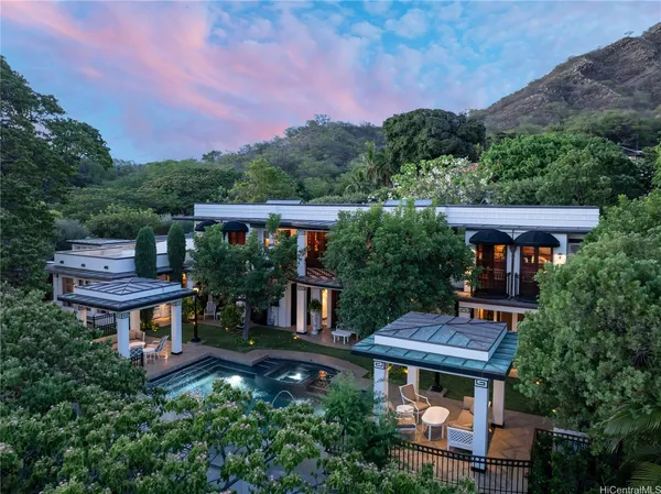 an aerial view of a house with balcony and trees al around