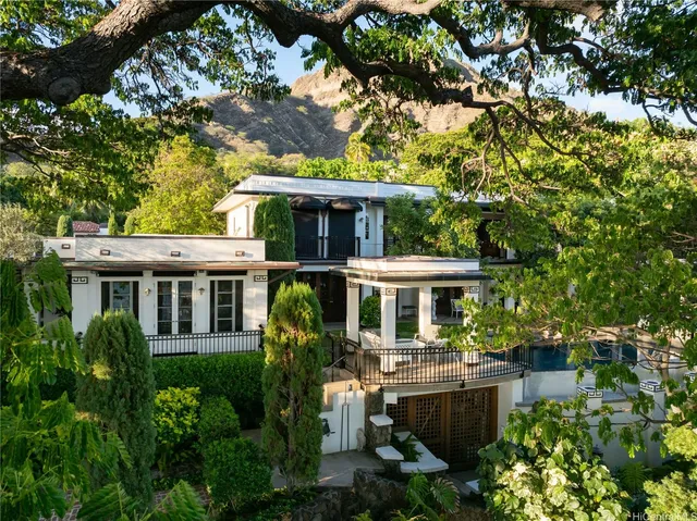 a front view of a house with a yard and potted plants