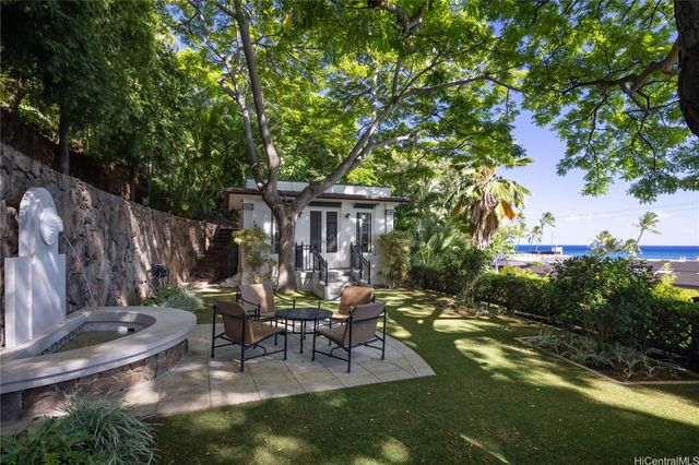 a view of backyard with table and chairs and a lots of green space