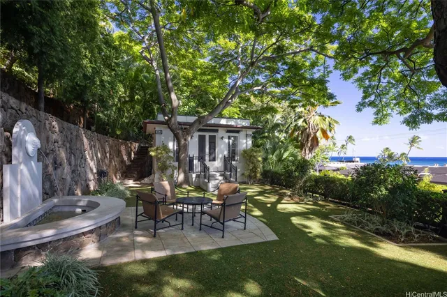 a view of backyard with table and chairs and a lots of green space