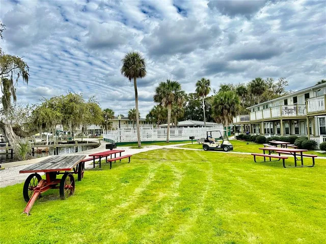 a view of swimming pool with lawn chairs and iron fence