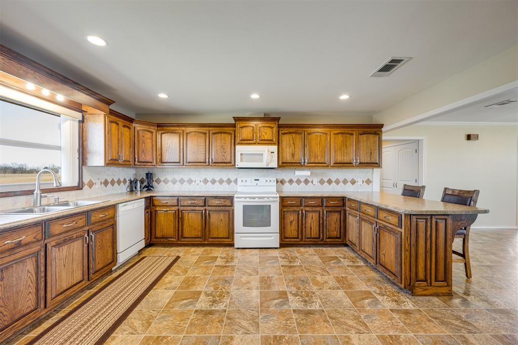 3418 Fm 38 Street North Brookston, TX 75421 - Photo 7 of 22 a large kitchen with stainless steel appliances granite countertop a large stove a sink and a microwave