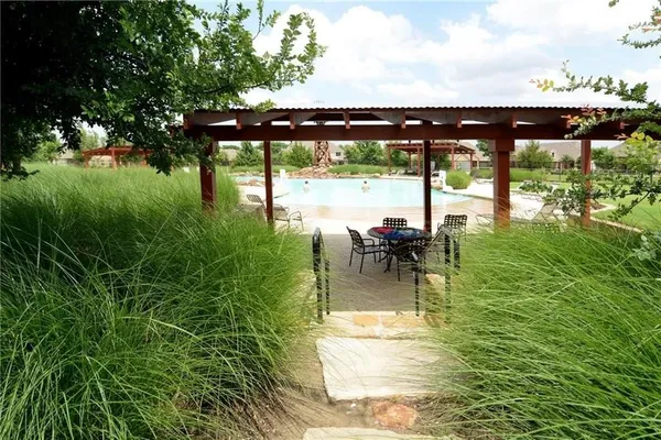 a swimming pool with lawn chairs yard