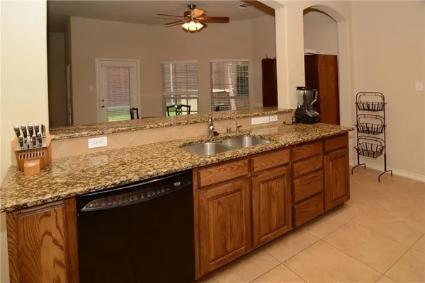 a bathroom with a granite countertop double vanity sink and a mirror