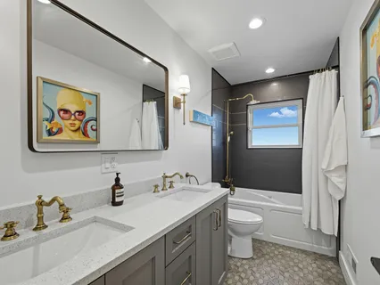 a bathroom with a granite countertop sink toilet and shower