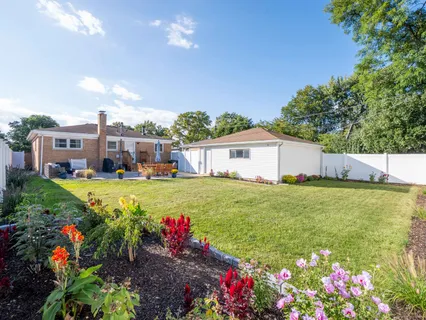 a front view of a house with a big yard and potted plants