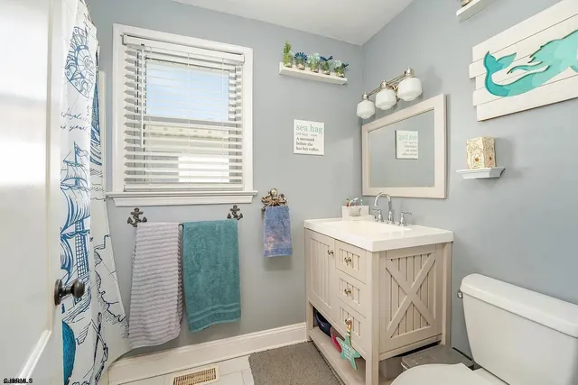 a bathroom with a sink a toilet and mirror