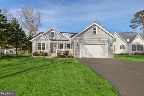 a front view of a house with a yard and trees