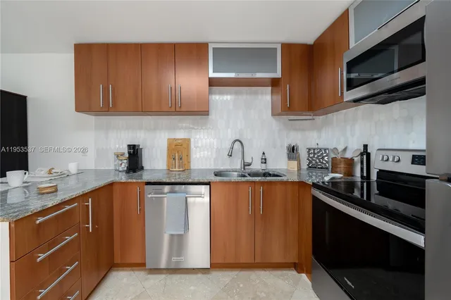 a kitchen with stainless steel appliances granite countertop a sink stove and microwave
