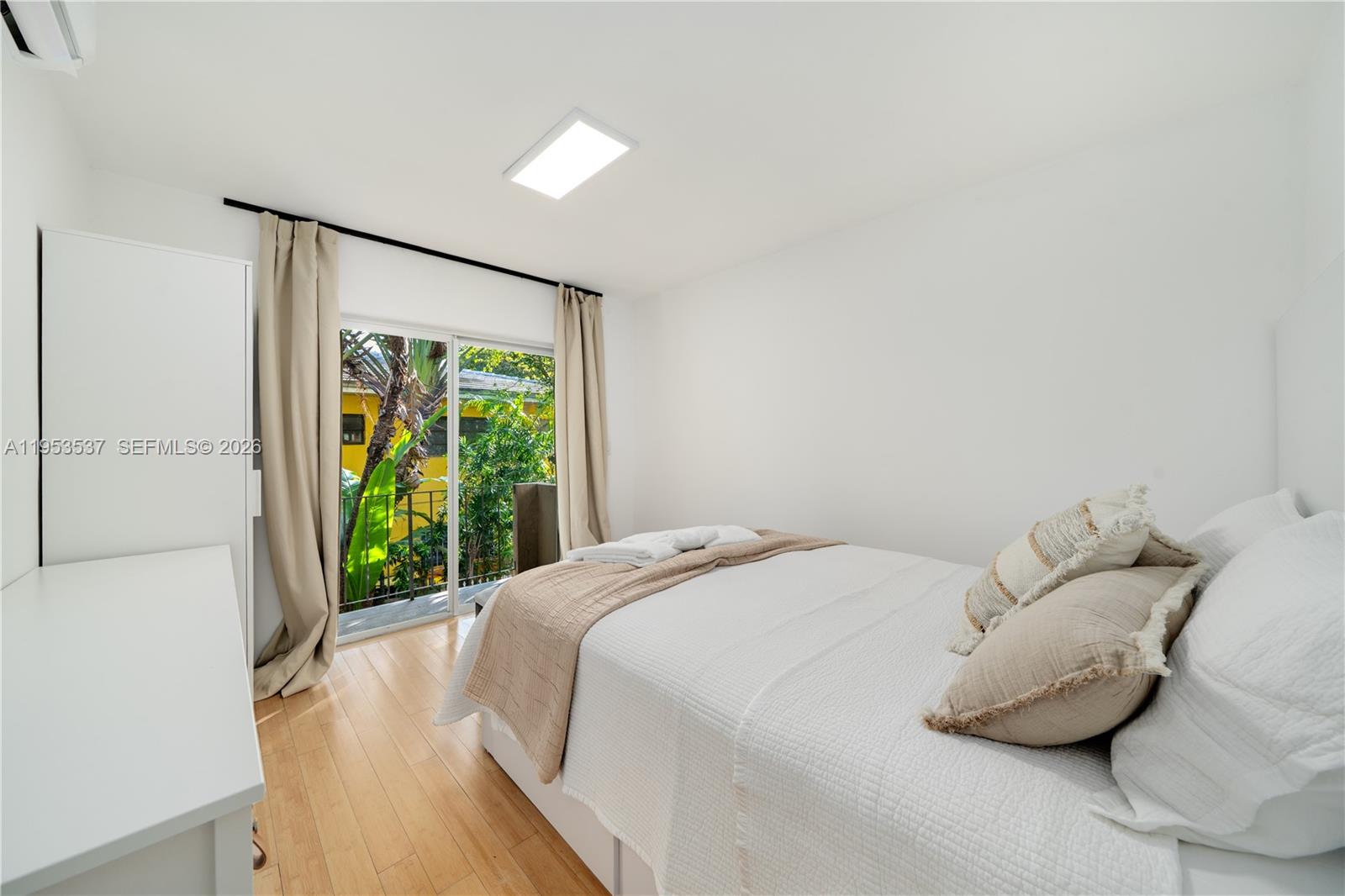 651 Northeast 60th Street, Unit 25 Miami, FL 33137 - Photo 14 of 23 a bed sitting in a bedroom next to a window