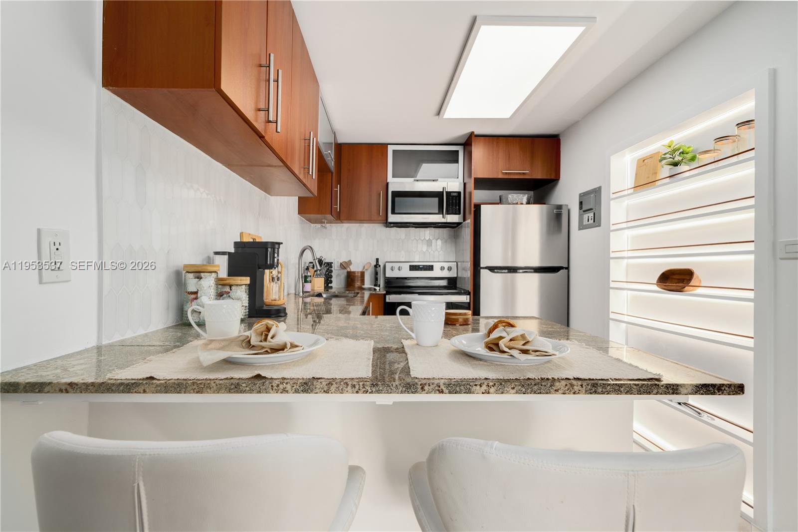 651 Northeast 60th Street, Unit 25 Miami, FL 33137 - Photo 3 of 23 a kitchen with kitchen island granite countertop a sink appliances and cabinets